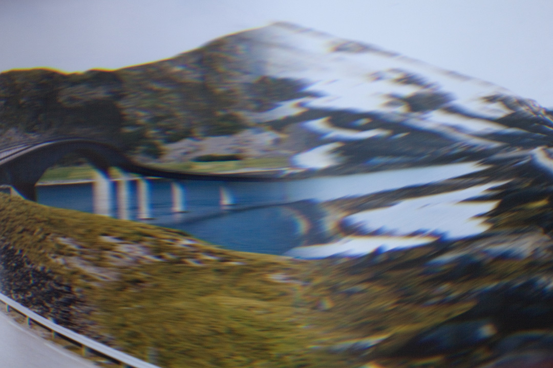 Abstrakte Fotografie von einer Landschaft mit Schnee, Bergen und einer Brücke.