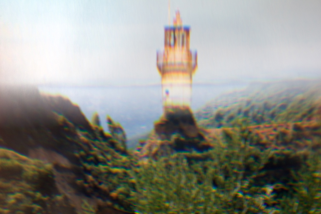Künstlerische Fotografie von einem transparenten Leuchtturm am Meer.