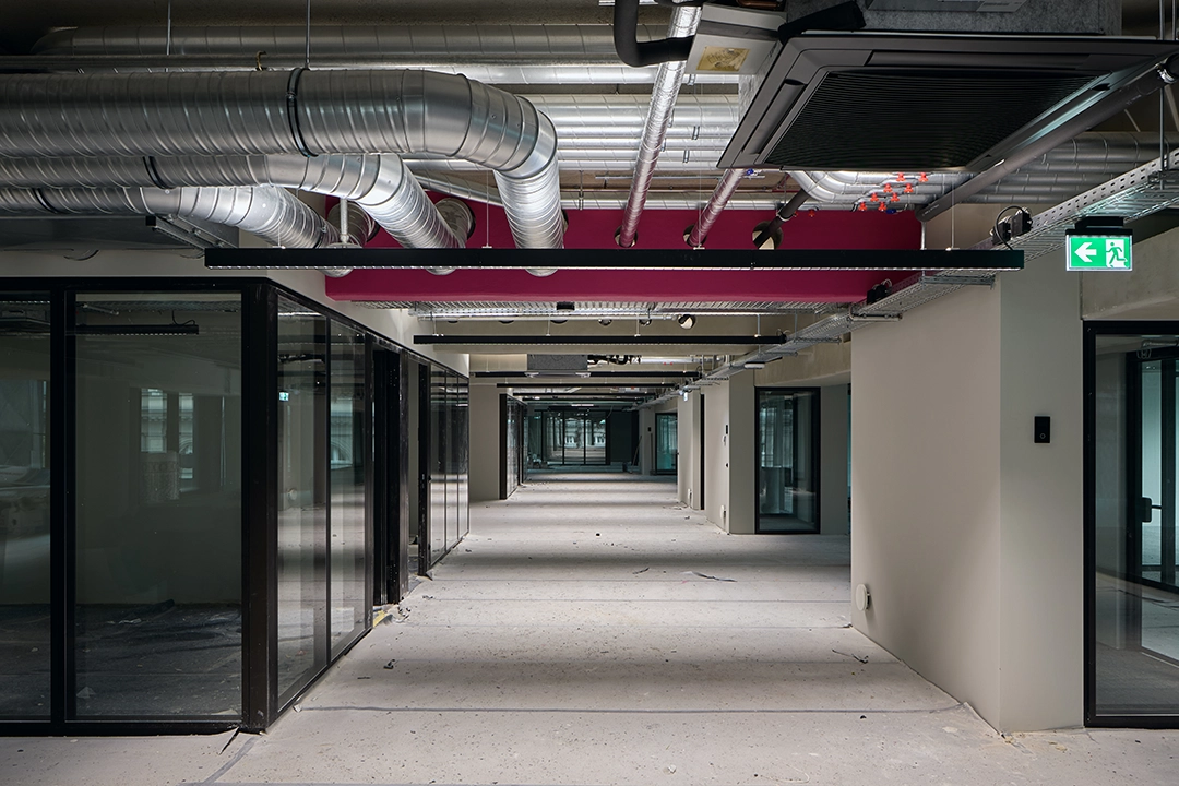 Foto von einer Baustelle, die fast fertig gestellt ist. Ein Gang mit offener Deckenkonstruktion. 